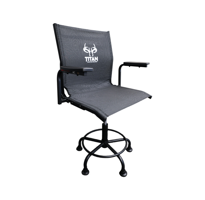 A modern hunting chair with a dark gray textured mesh seat and backrest, featuring a white 'TITAN' logo on the backrest. It has black armrests, a black swivel base, and castor wheels, shown against a plain white background.